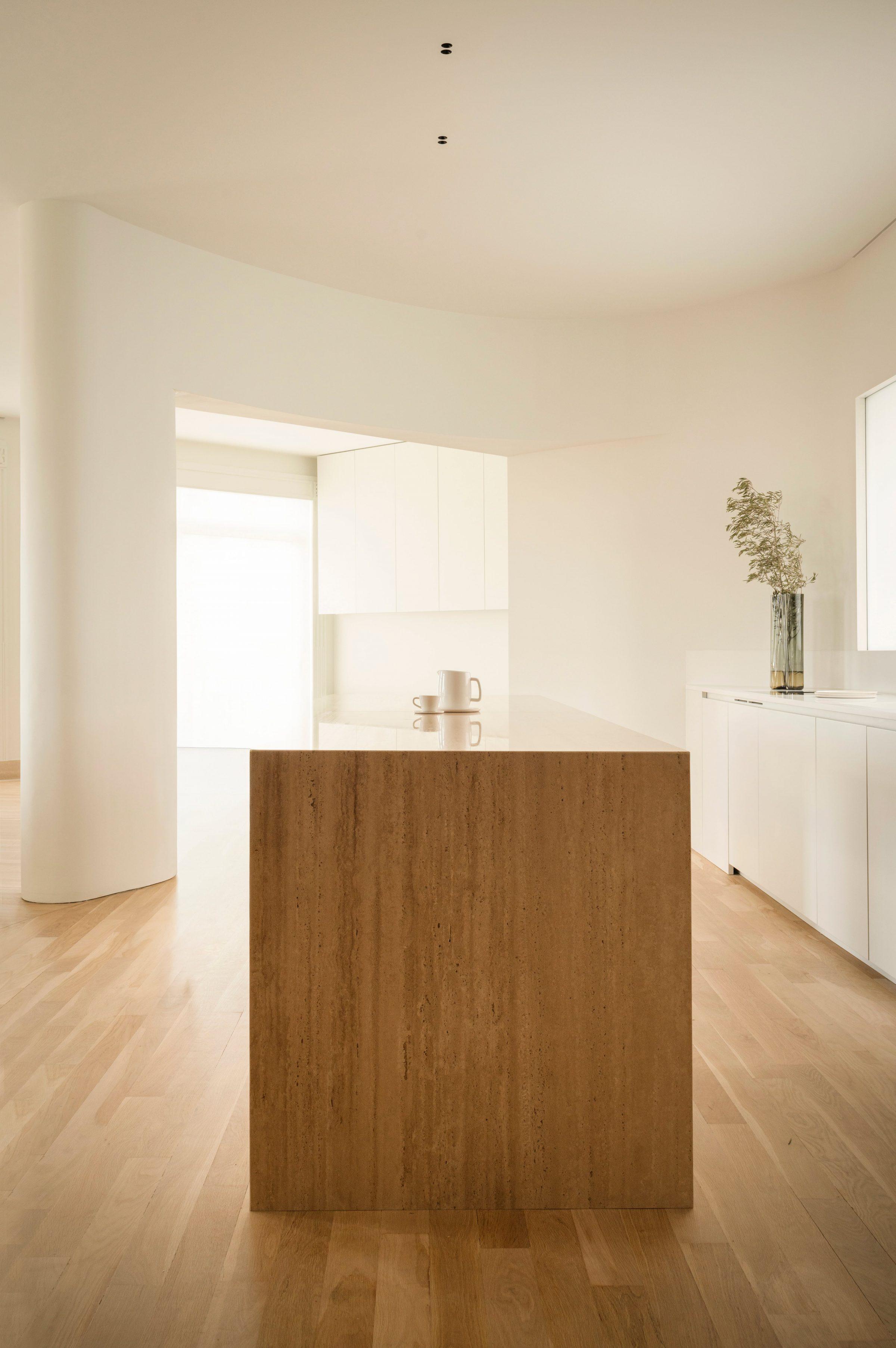 1928 Penthouse — kitchen island in warm timber, daylight from the balcony
