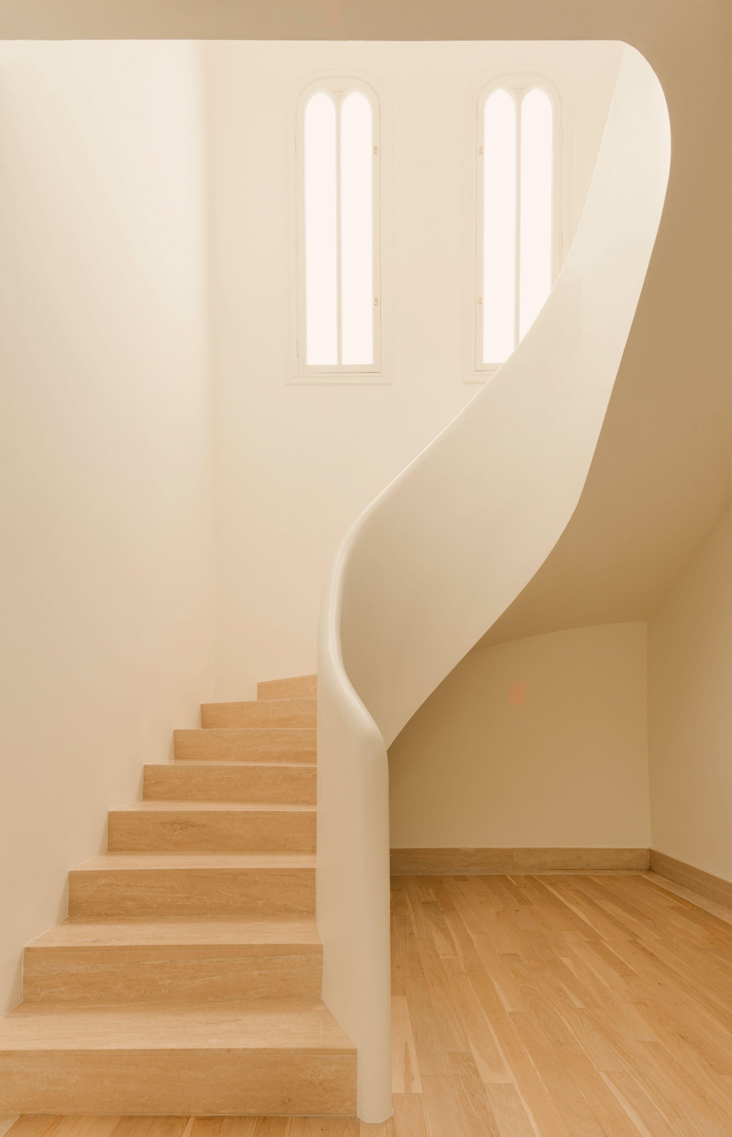 1928 Penthouse — curved staircase joining the two levels, original window openings