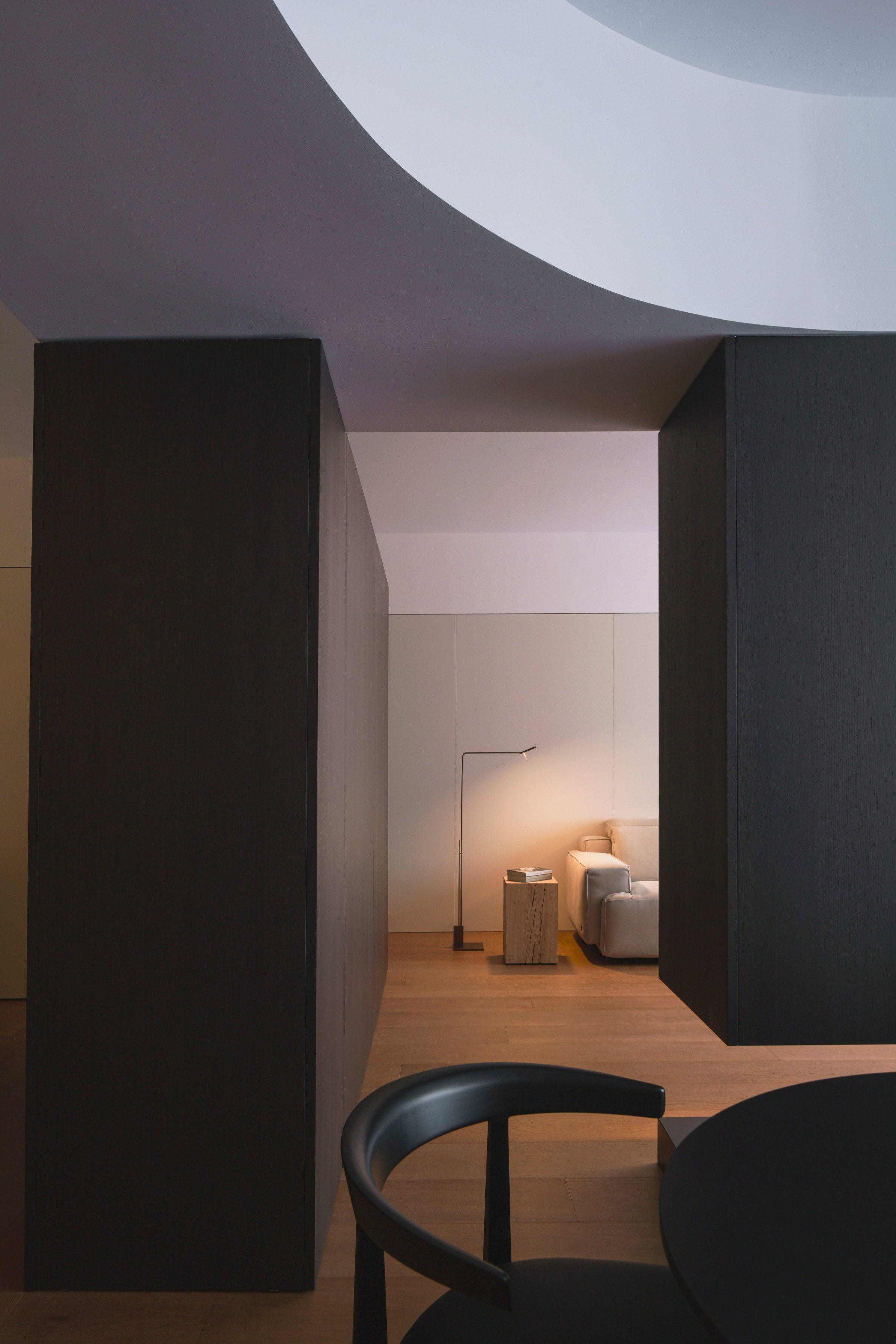 AO17 Apartment — dark walnut volumes framing a view of the white-domed ceiling