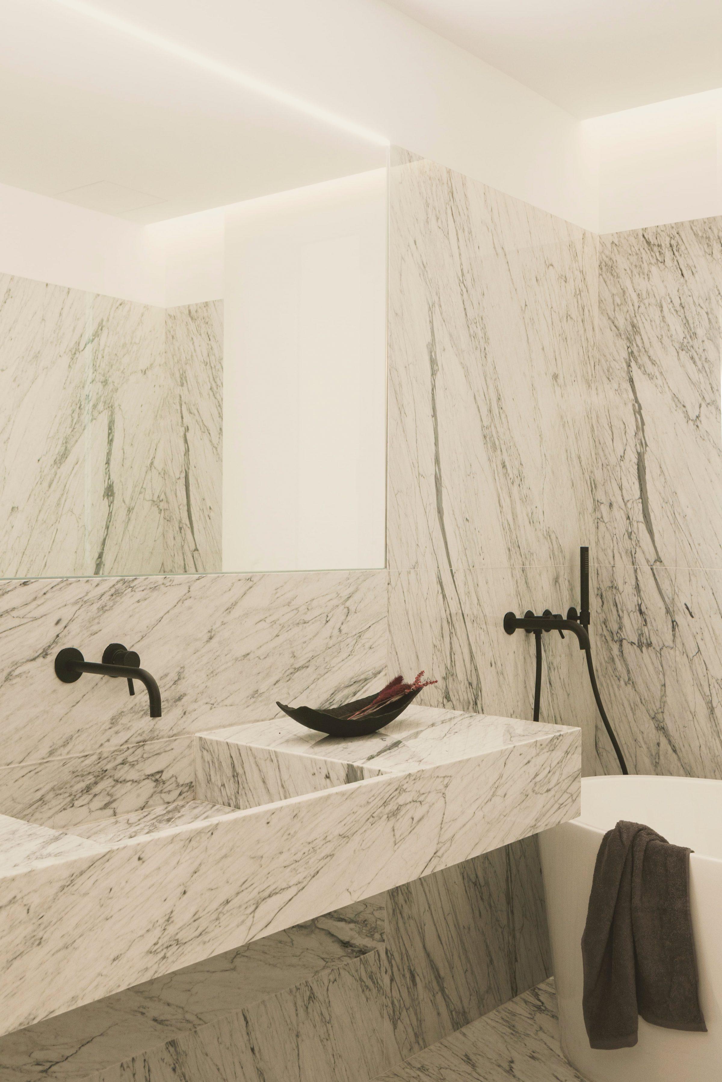 AO17 Apartment — Carrara marble bathroom volume, sink and bath in a single material