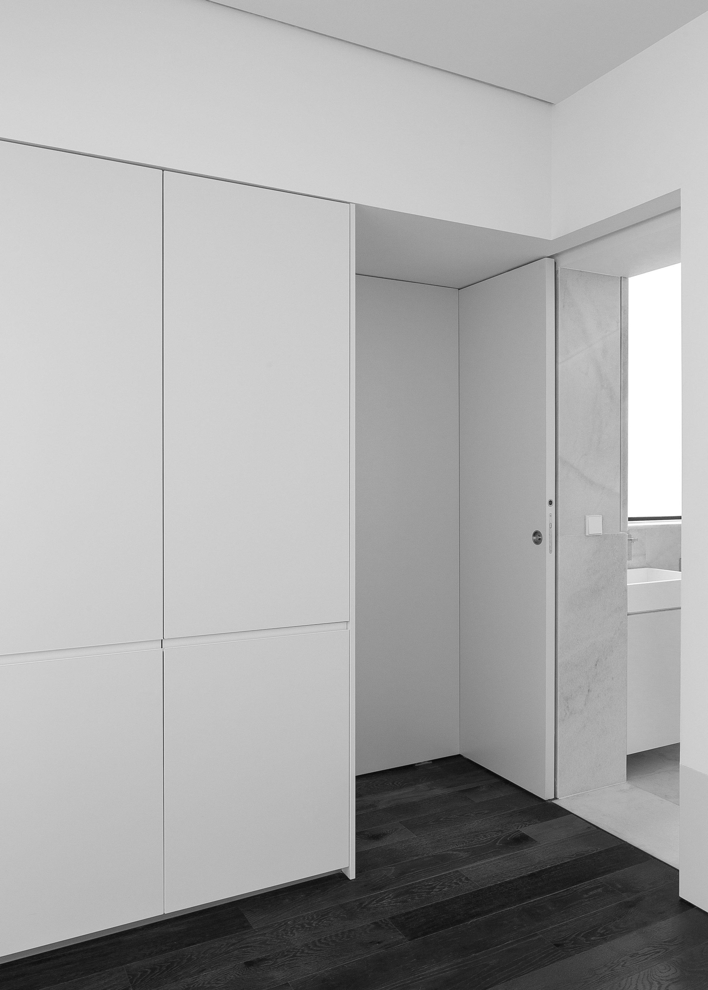 Murcia Apartment, white pivoting and sliding panels closed flush