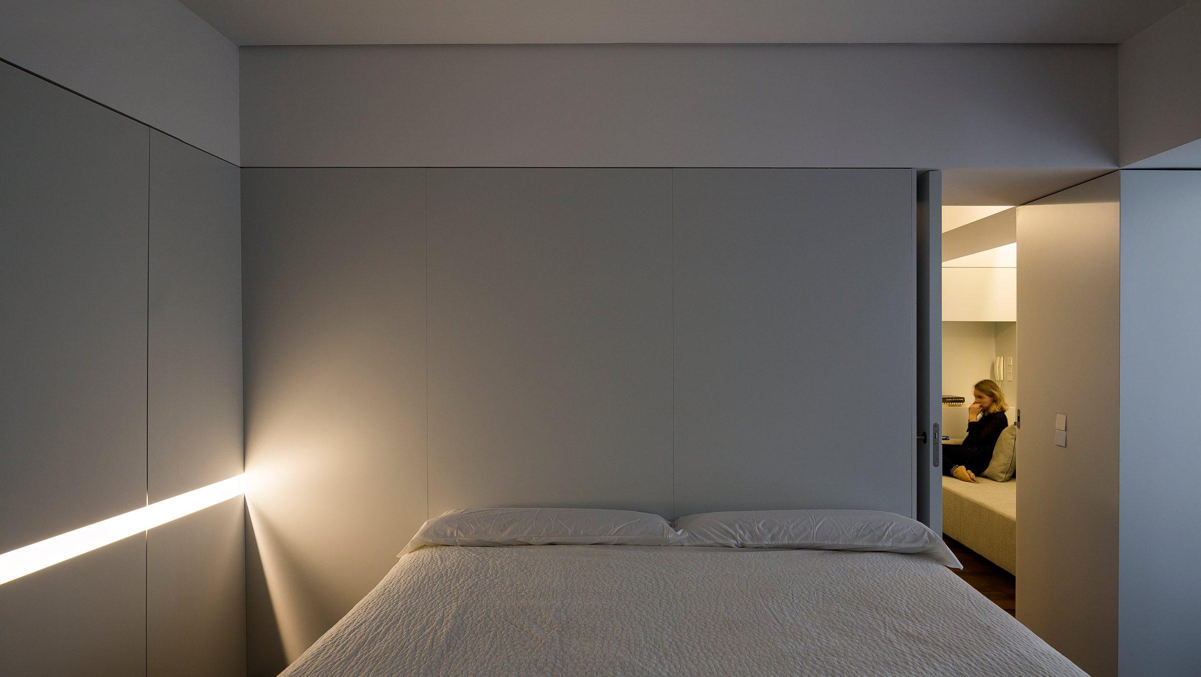 Murcia Apartment, the bedroom at night, indirect warm light along the wardrobe