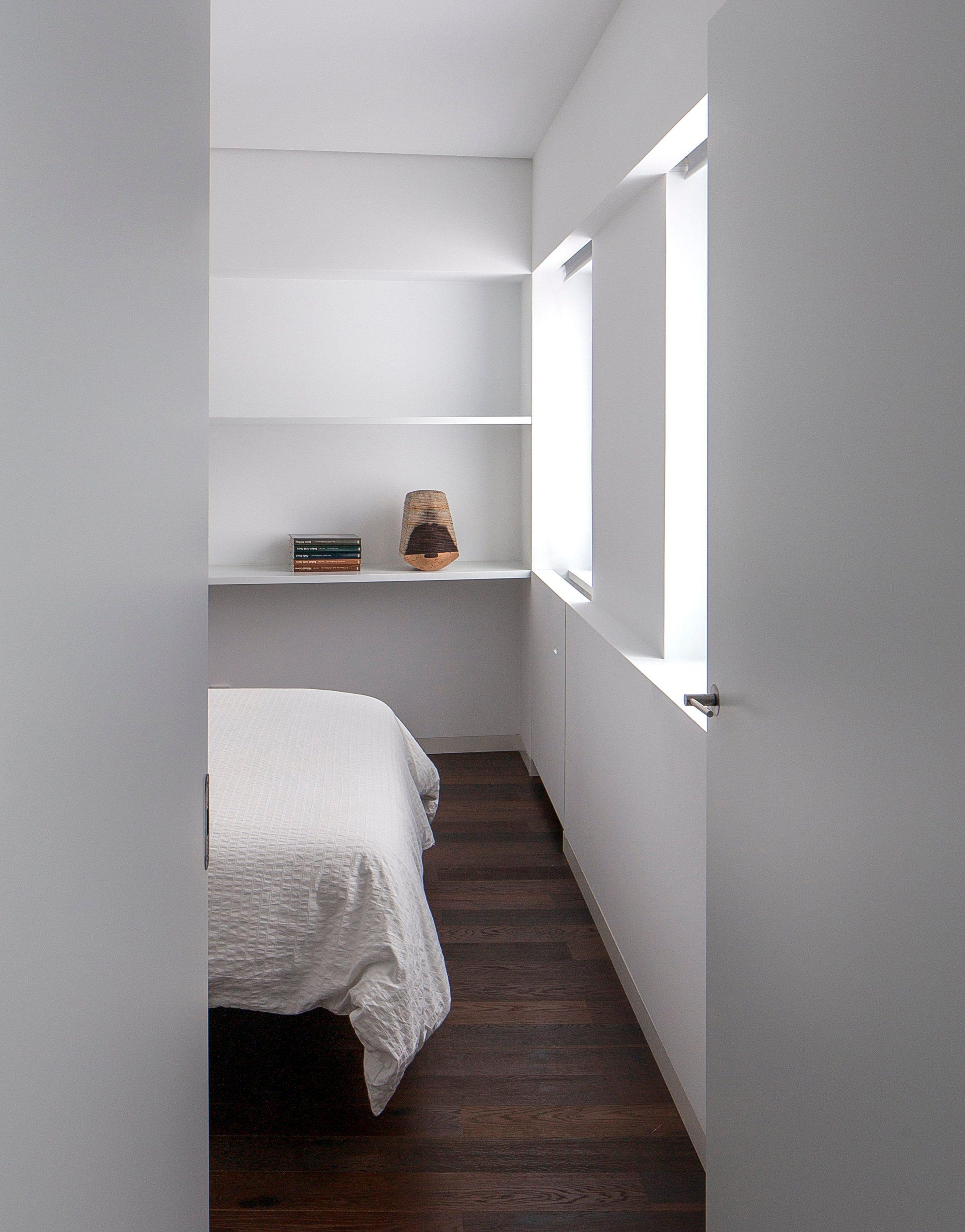 Murcia Apartment, a built-in shelf and a slit of light beside the bed