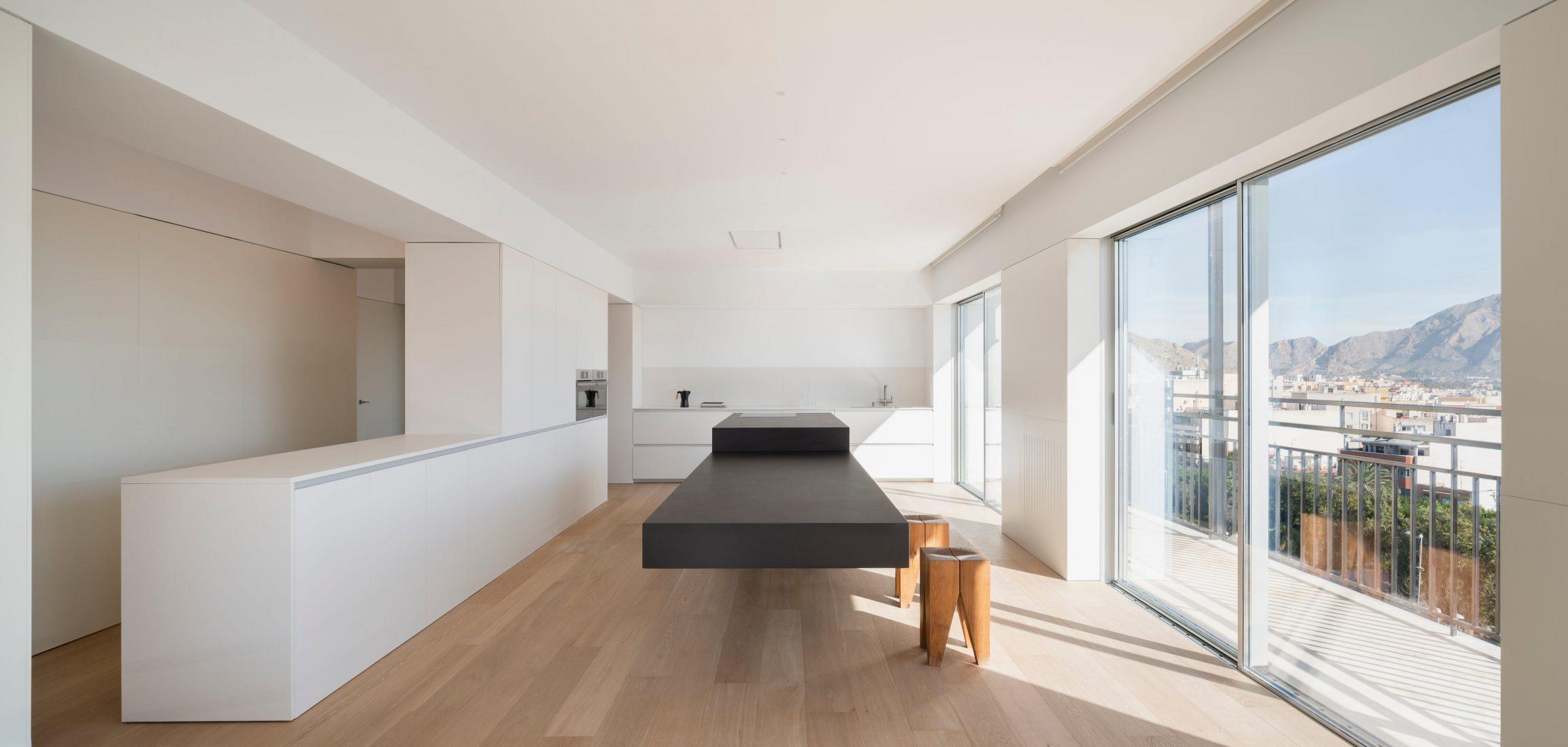 Orihuela Apartment, the longitudinal living room, kitchen island and the view towards the Callosa and Orihuela ranges