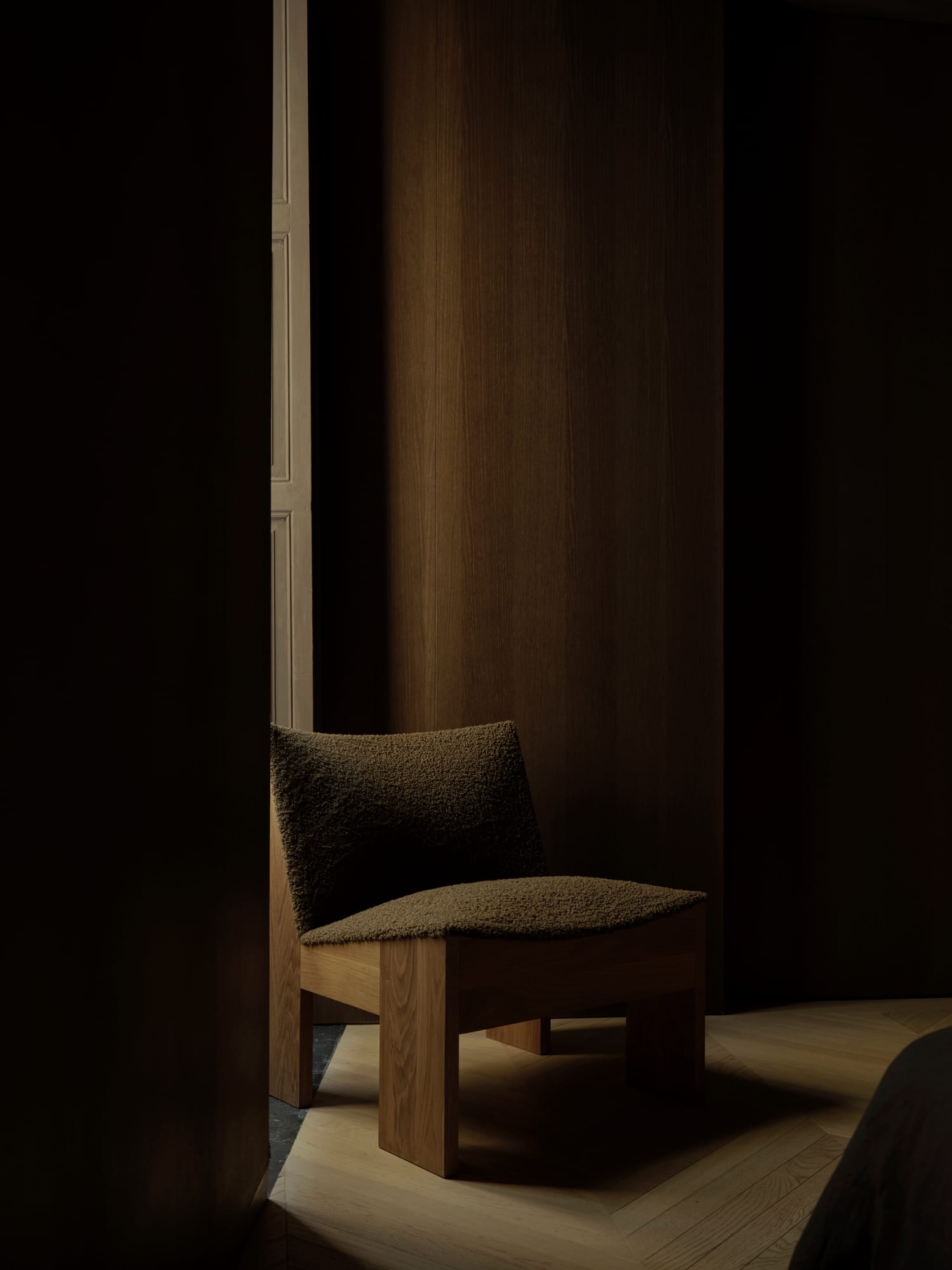 Ciutat Vella Apartment — bouclé armchair in the dark-oak private wing