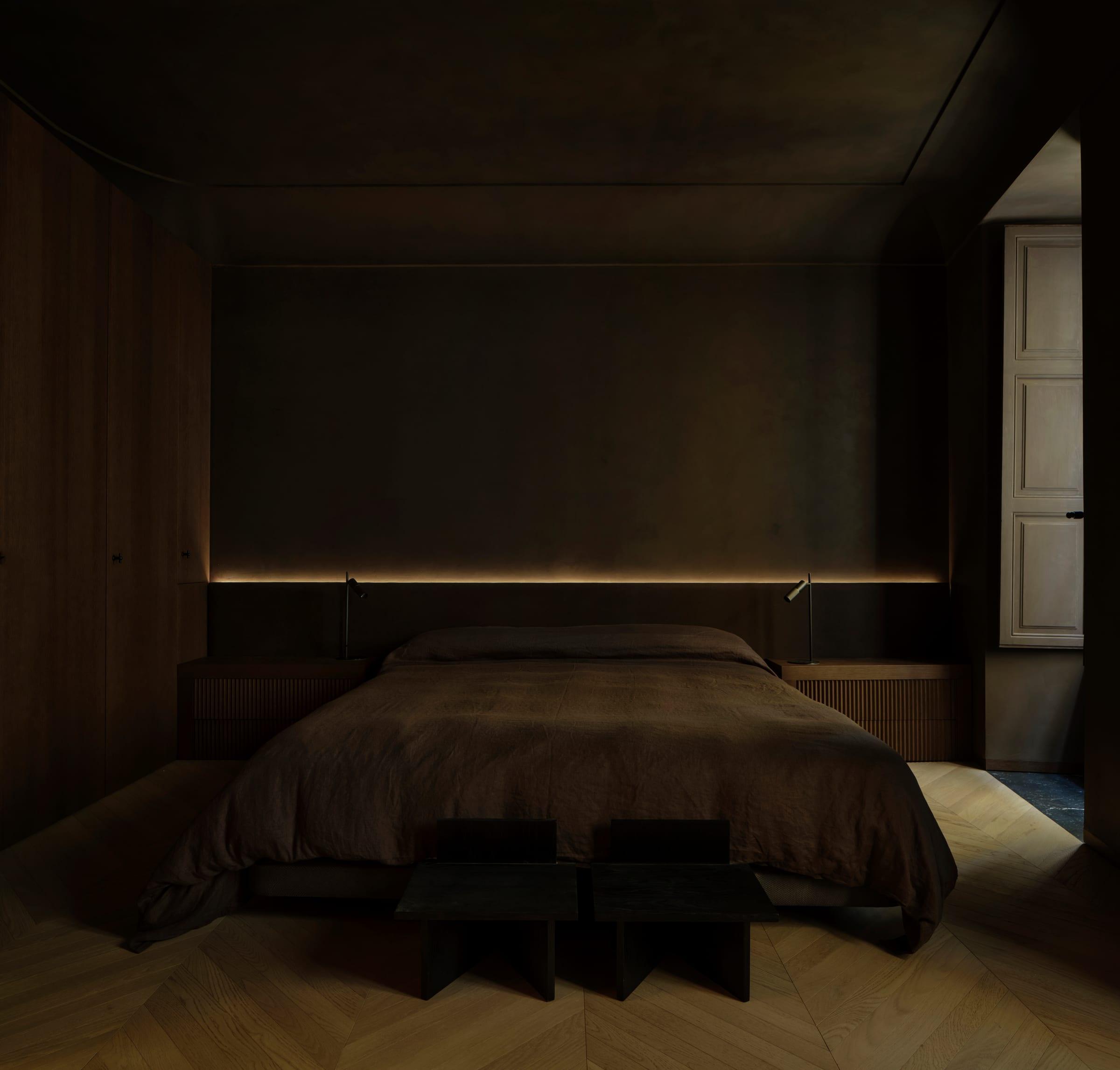Ciutat Vella Apartment — private bedroom lined in dark oak, light run indirectly along the panelling