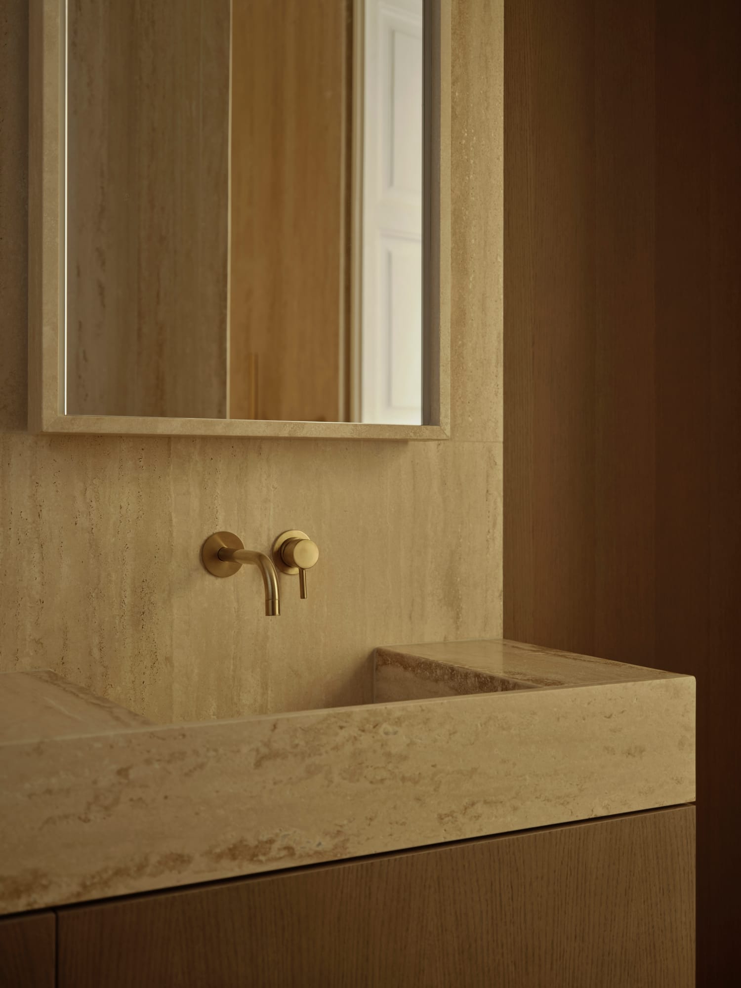 Ciutat Vella Apartment — travertine washbasin warmed by brass
