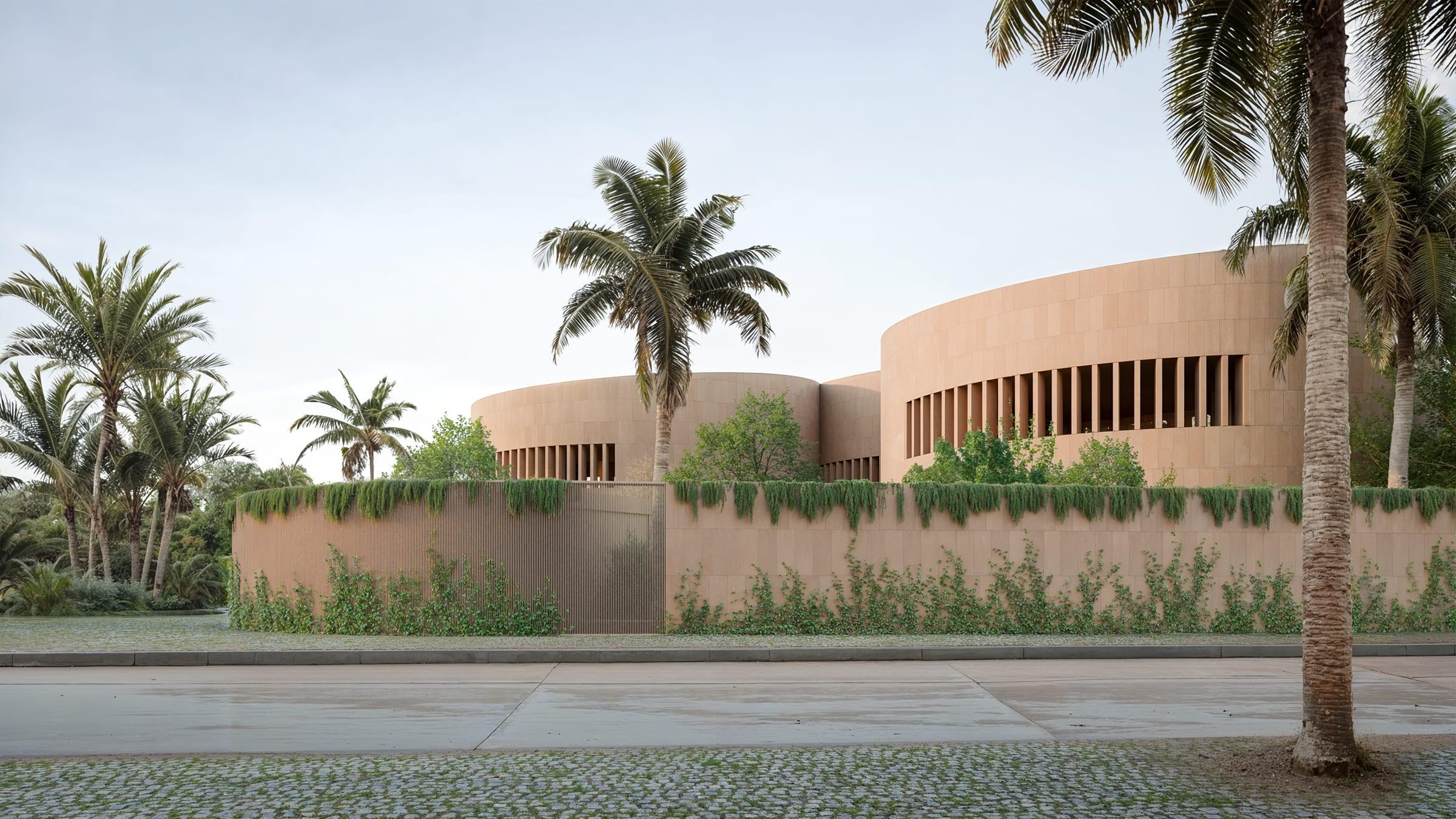 Round House — street view, three circular volumes behind the planted perimeter wall