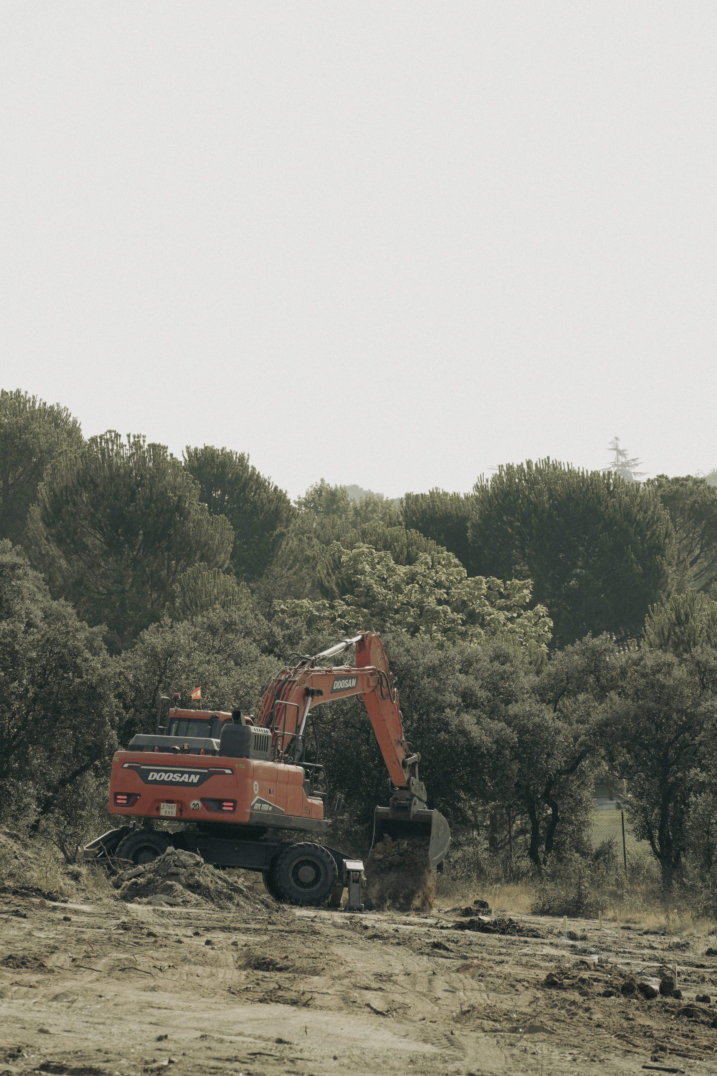 Moraleja CN6 House, an excavator working among the retained oaks during the earthworks